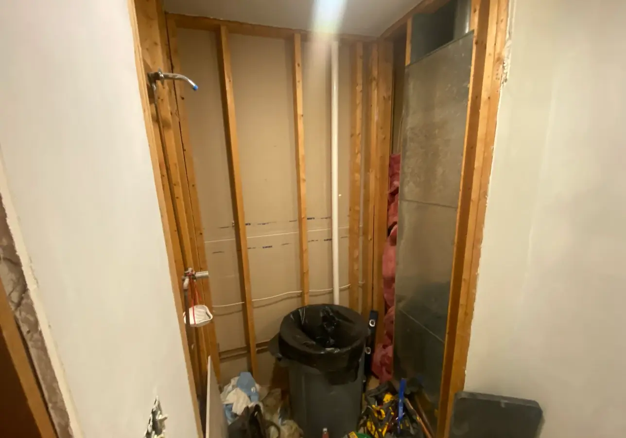 Basement bathroom before, bare studs and plumbing rough-in